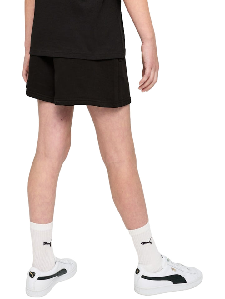 Mujer vistiendo shorts deportivos negros de marca PUMA con logo blanco lateral.