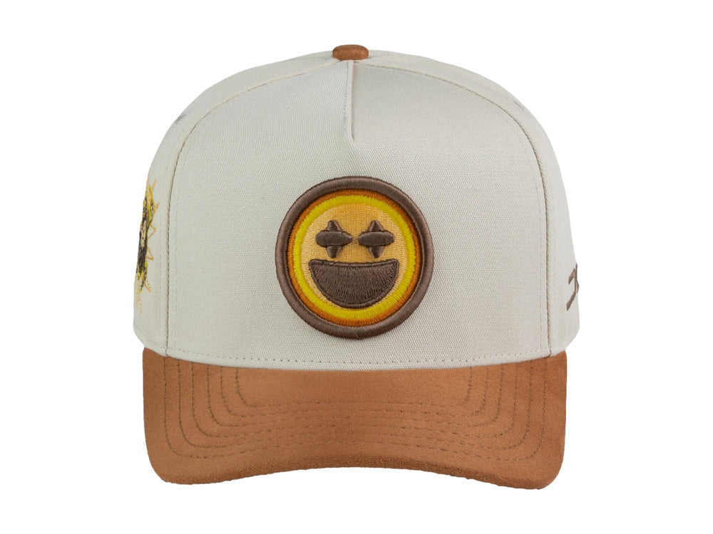 Gorra snapback color beige con visera marrón y un parche frontal de carita feliz amarilla.