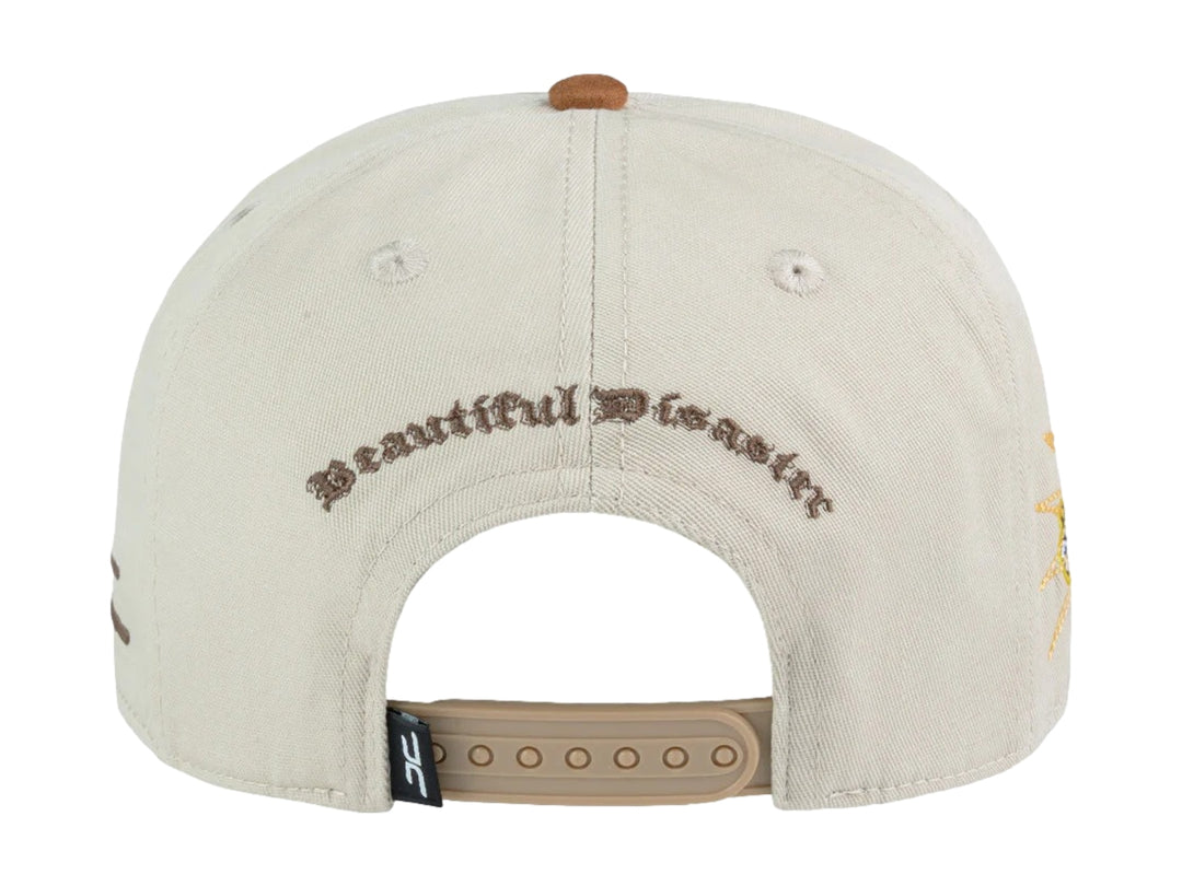 Gorra snapback color beige con visera marrón y un parche frontal de carita feliz amarilla.