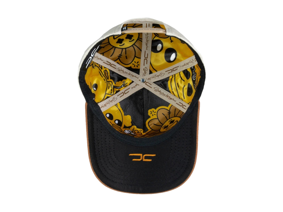 Gorra snapback color beige con visera marrón y un parche frontal de carita feliz amarilla.