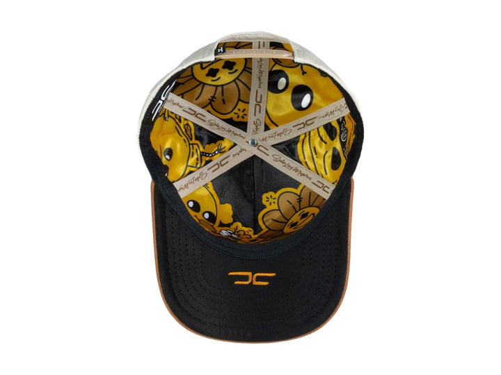 Gorra snapback color beige con visera marrón y un parche frontal de carita feliz amarilla.
