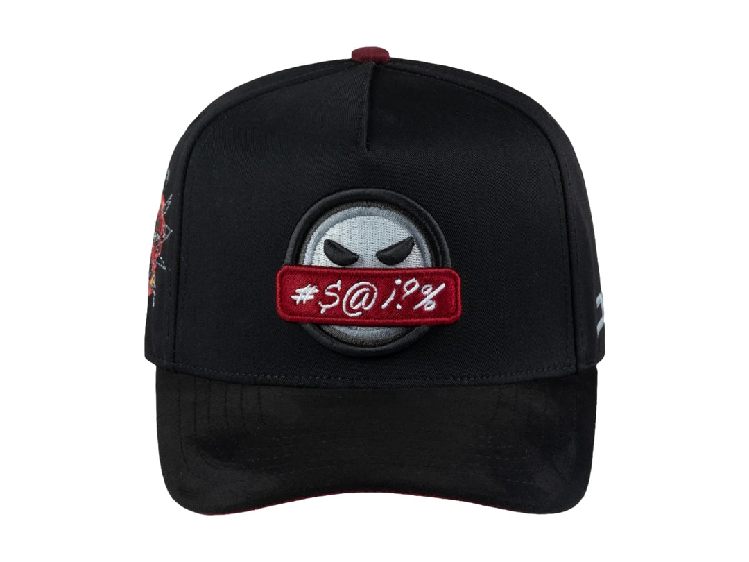 Gorra snapback negra con visera plana y un parche frontal de una cara con una franja roja de censura.