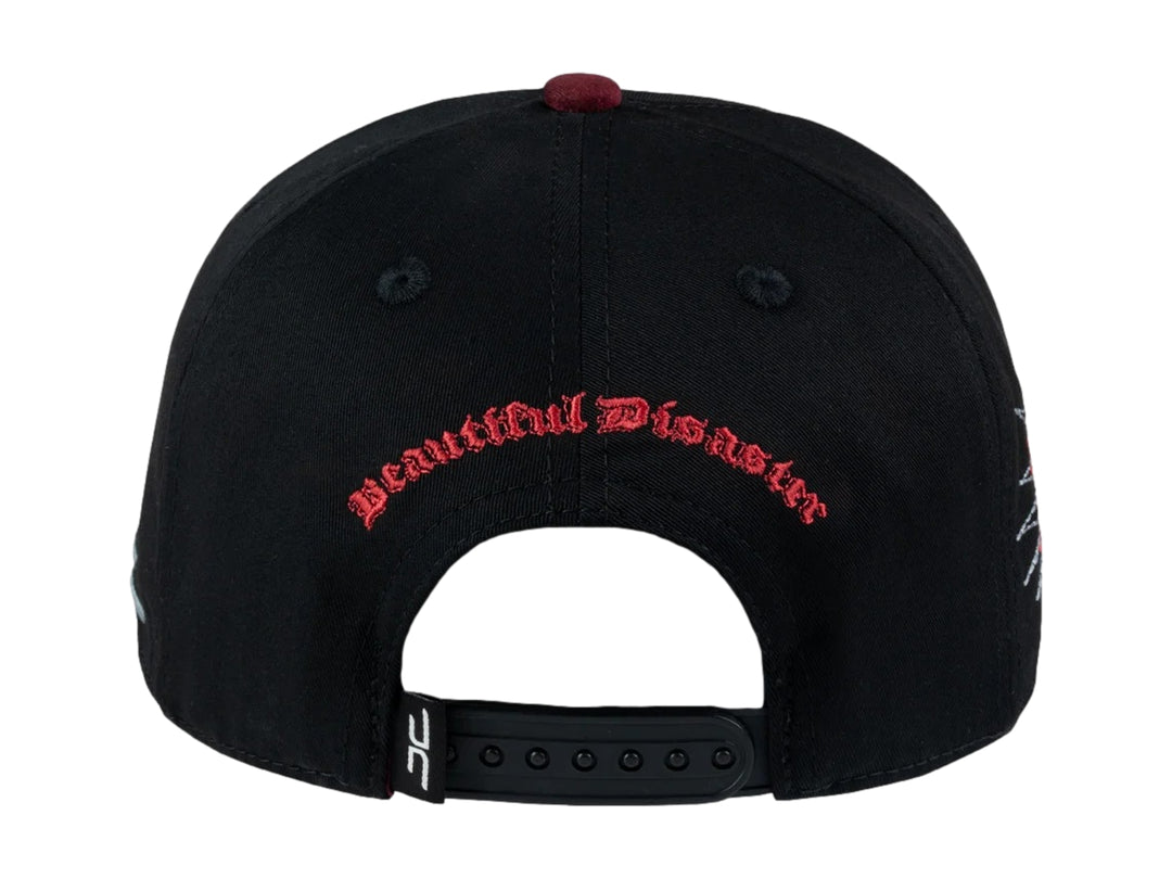 Gorra snapback negra con visera plana y un parche frontal de una cara con una franja roja de censura.