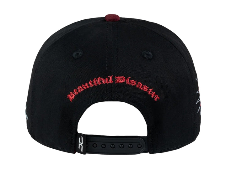 Gorra snapback negra con visera plana y un parche frontal de una cara con una franja roja de censura.