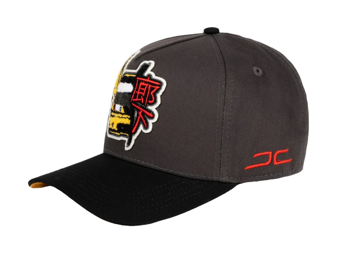 Gorra JC HATS color charcoal con visera negra y bordados decorativos en el frente y lateral.