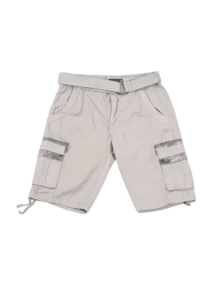 Hombre usando bermuda cargo color gris claro, camiseta gris y tenis beige sobre fondo blanco.