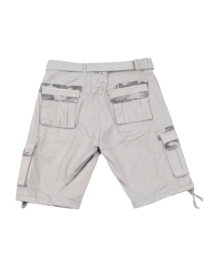 Hombre usando bermuda cargo color gris claro, camiseta gris y tenis beige sobre fondo blanco.
