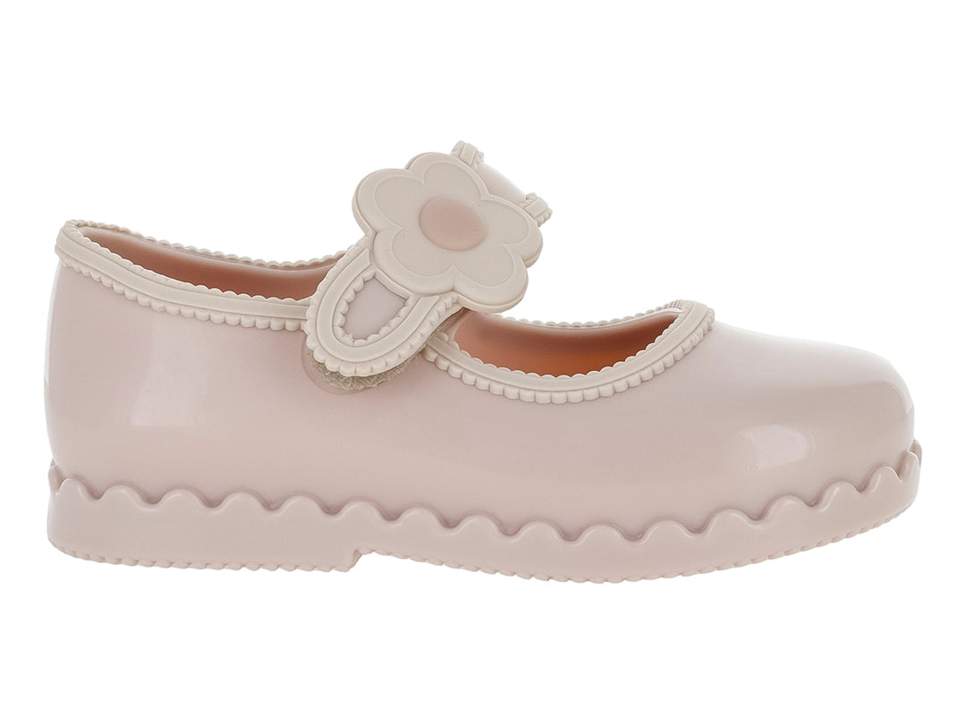 Zapato infantil Mini Melissa color rosa con adorno de flor y suela ondulada.