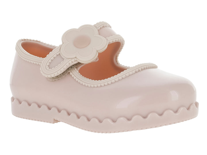 Zapato infantil Mini Melissa color rosa con adorno de flor y suela ondulada.