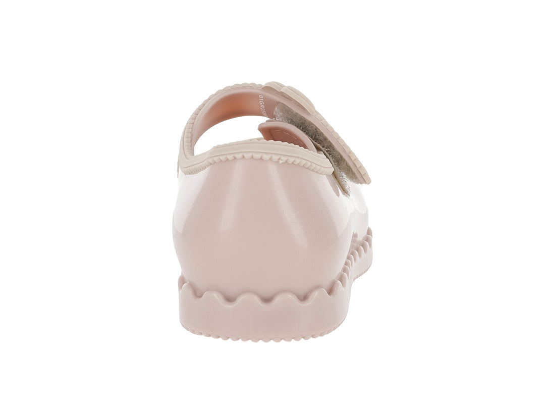 Zapato infantil Mini Melissa color rosa con adorno de flor y suela ondulada.