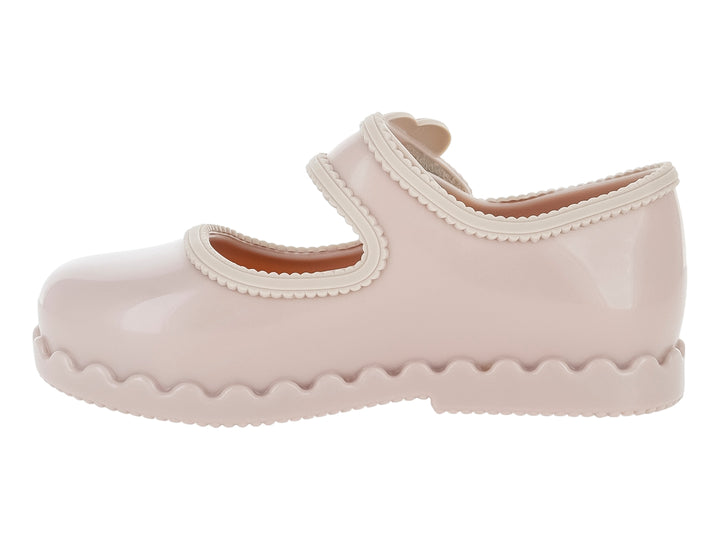 Zapato infantil Mini Melissa color rosa con adorno de flor y suela ondulada.