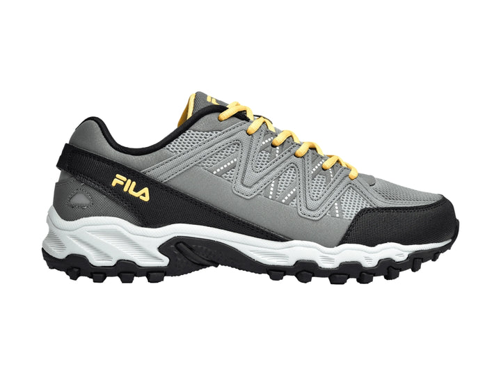 Tenis deportivos FILA para niños en color gris con detalles en negro, blanco y cordones amarillos.