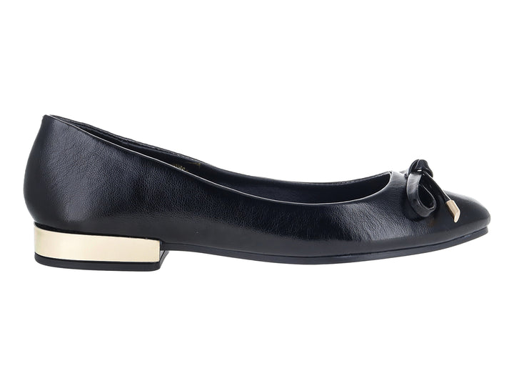 Zapato plano negro con moño decorativo y detalle dorado en el tacón.