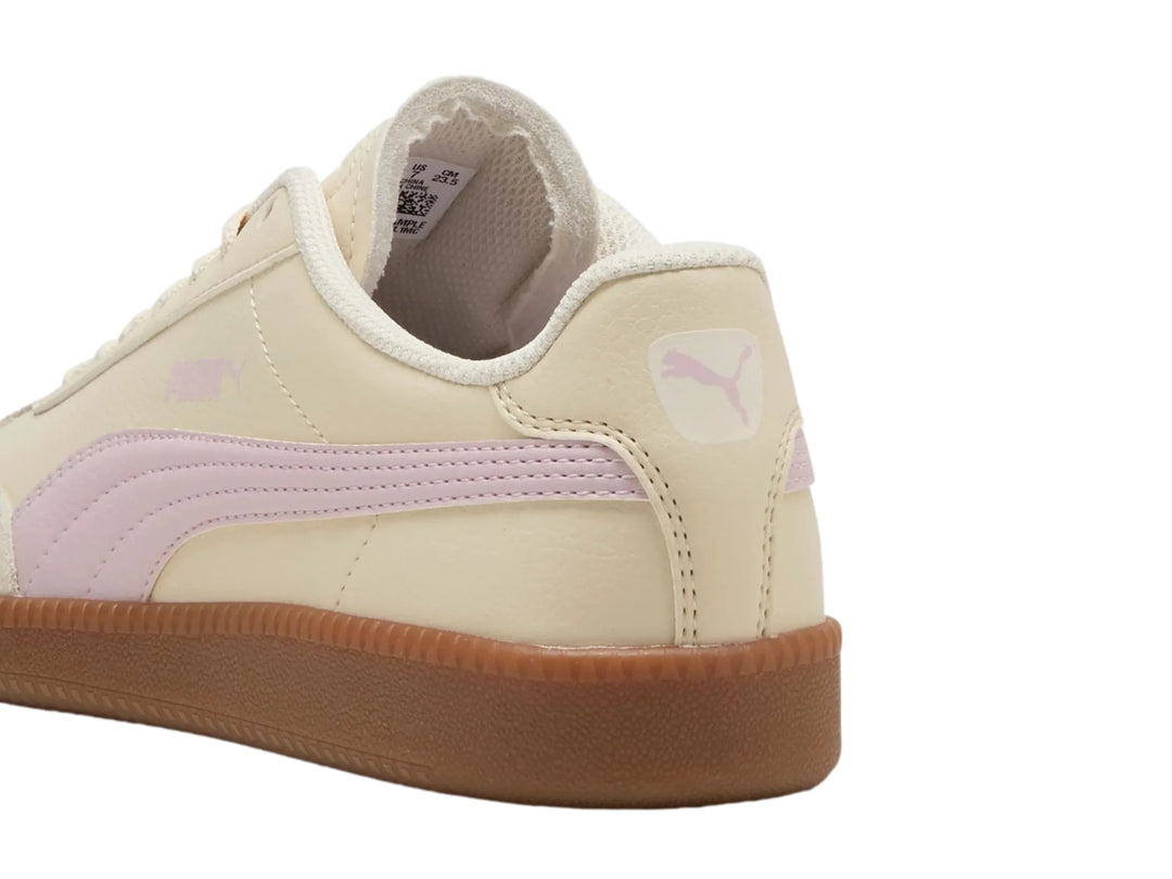 Tenis PUMA color blanco crema con franja lila y suela de goma color café.