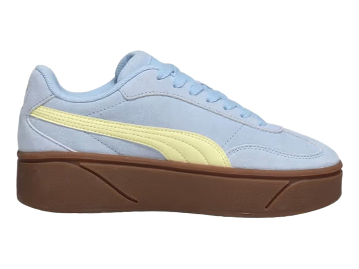 Tenis PUMA azul claro con franja amarilla y suela de plataforma marrón.