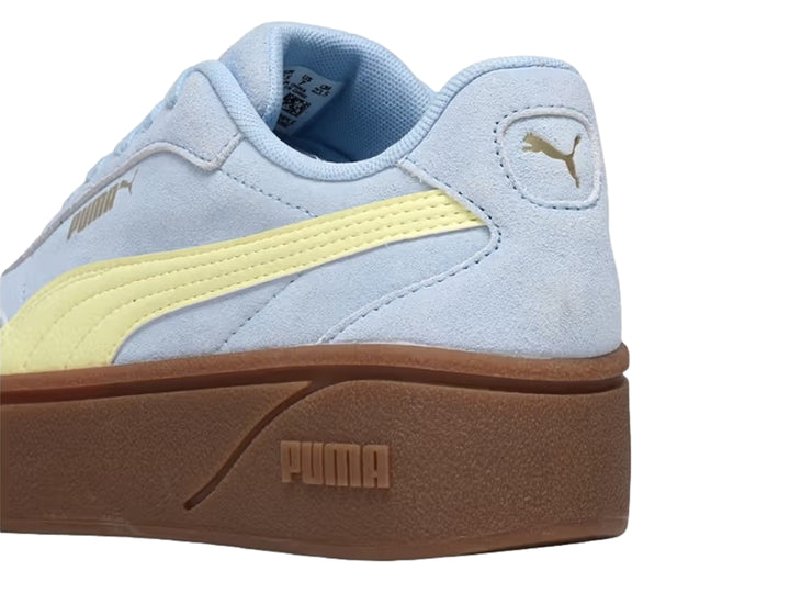 Tenis PUMA azul claro con franja amarilla y suela de plataforma marrón.