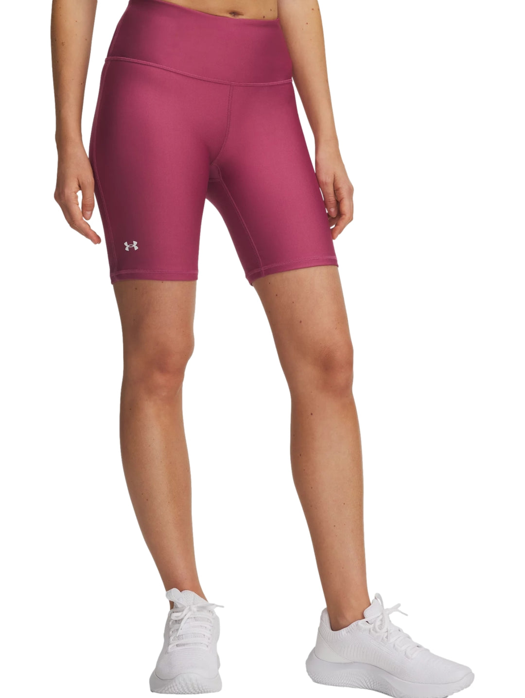 Mujer vistiendo shorts deportivos ajustados de color rojo magenta de la marca Under Armour.