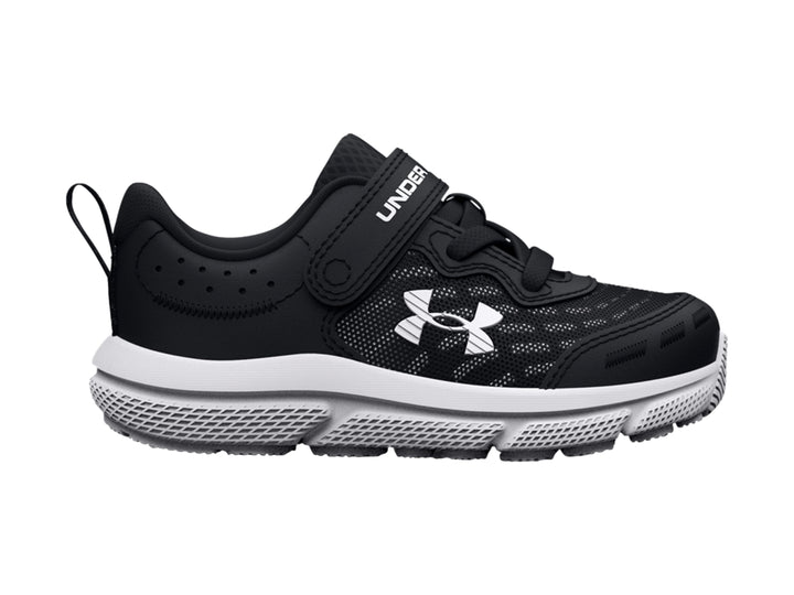 Tenis deportivos Under Armour para niño en color negro con suela blanca y cierre de correa con velcro.