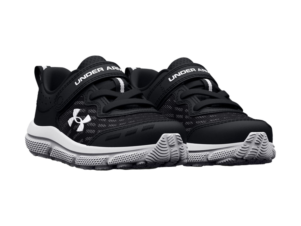 Tenis deportivos Under Armour para niño en color negro con suela blanca y cierre de correa con velcro.