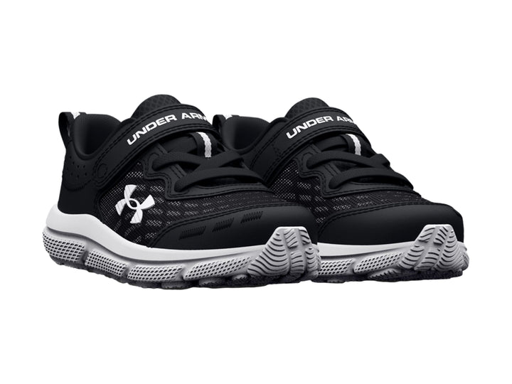 Tenis deportivos Under Armour para niño en color negro con suela blanca y cierre de correa con velcro.