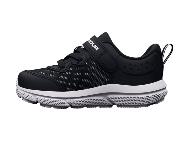 Tenis deportivos Under Armour para niño en color negro con suela blanca y cierre de correa con velcro.