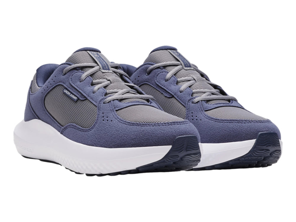 Tenis deportivos Under Armour color gris oscuro y gris con suela blanca.
