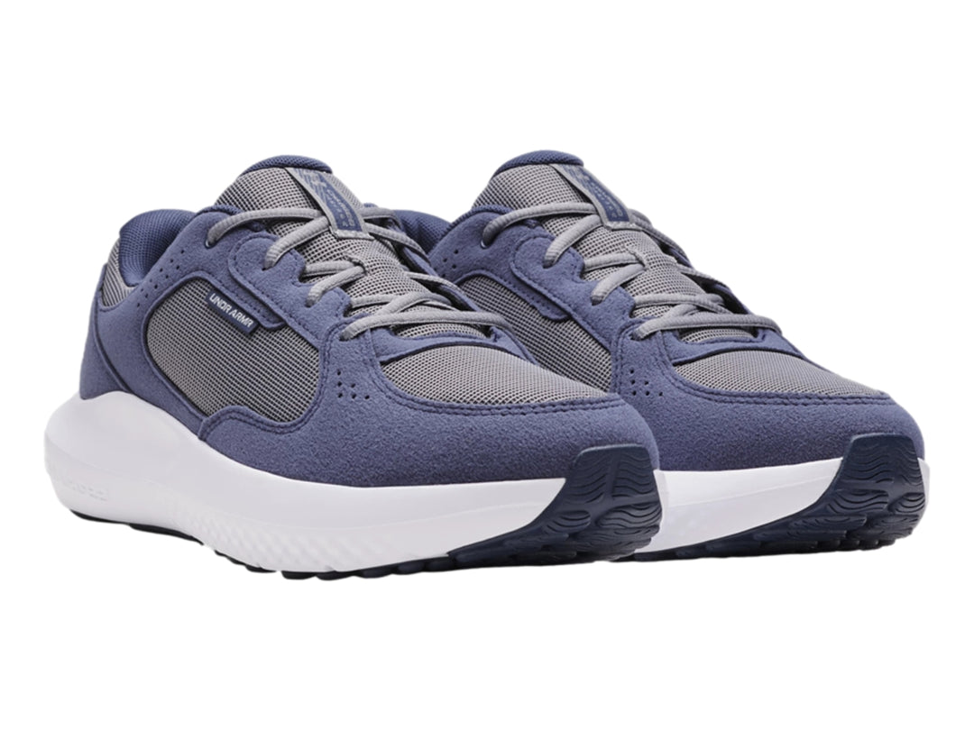 Tenis deportivos Under Armour color gris oscuro y gris con suela blanca.