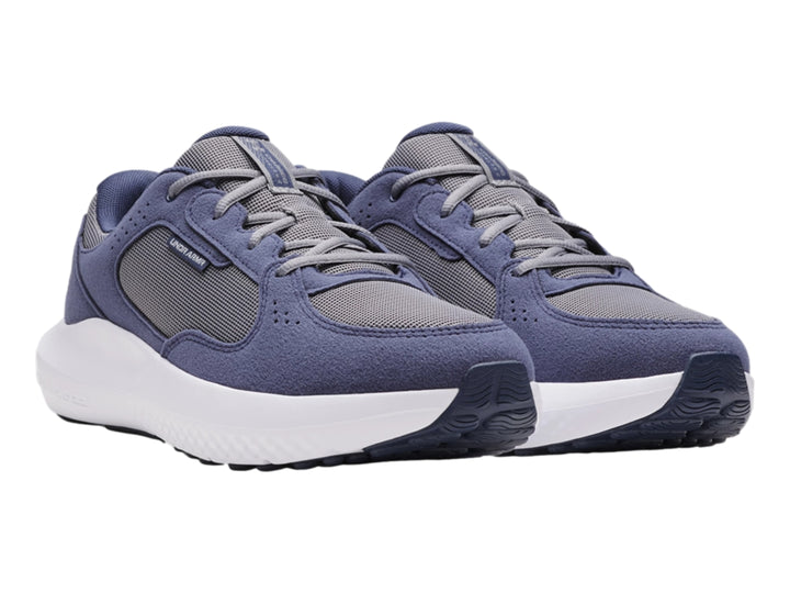 Tenis deportivos Under Armour color gris oscuro y gris con suela blanca.