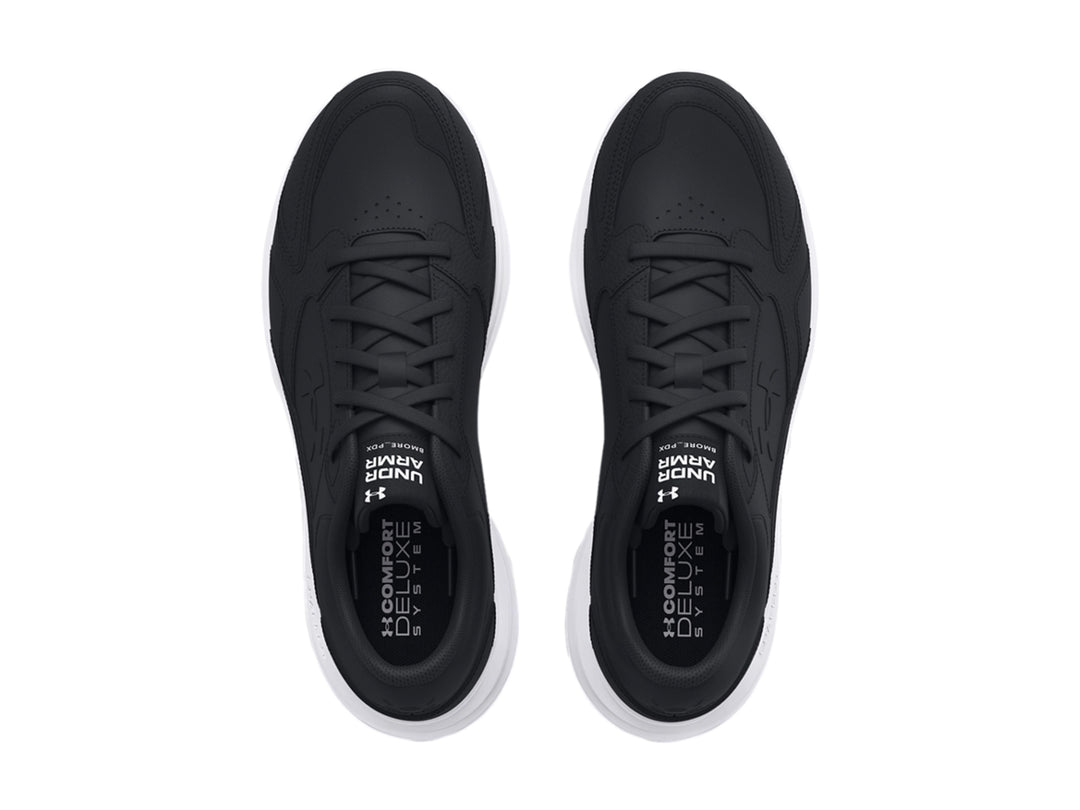 Tenis deportivos Under Armour color negro con suela blanca y detalles en cuero sintético.