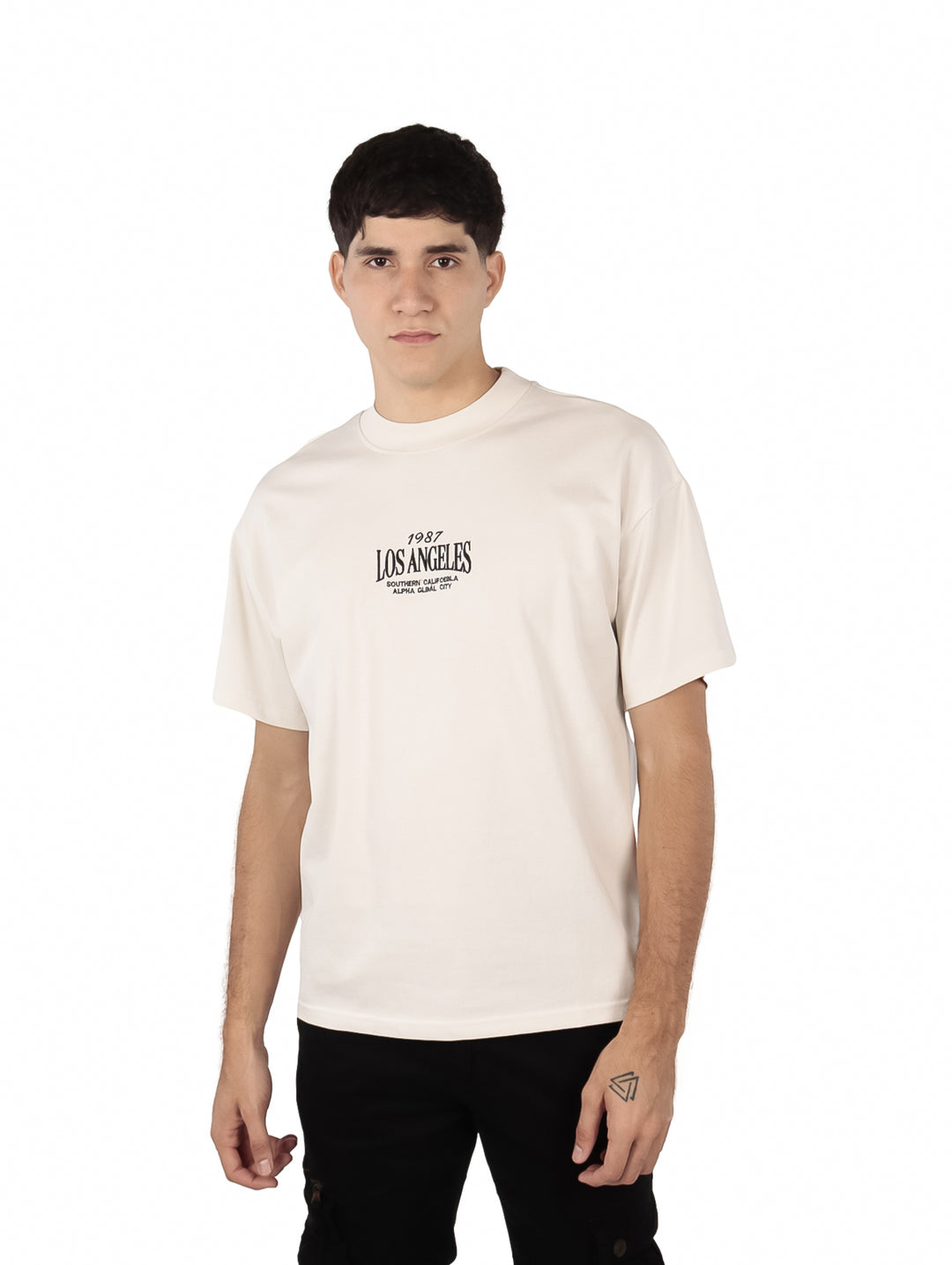 Hombre vistiendo playera oversize color beige con estampado de Los Angeles en el pecho.