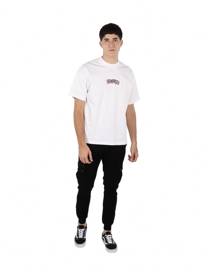 Hombre vistiendo playera blanca oversize de manga corta con estampado en el pecho.