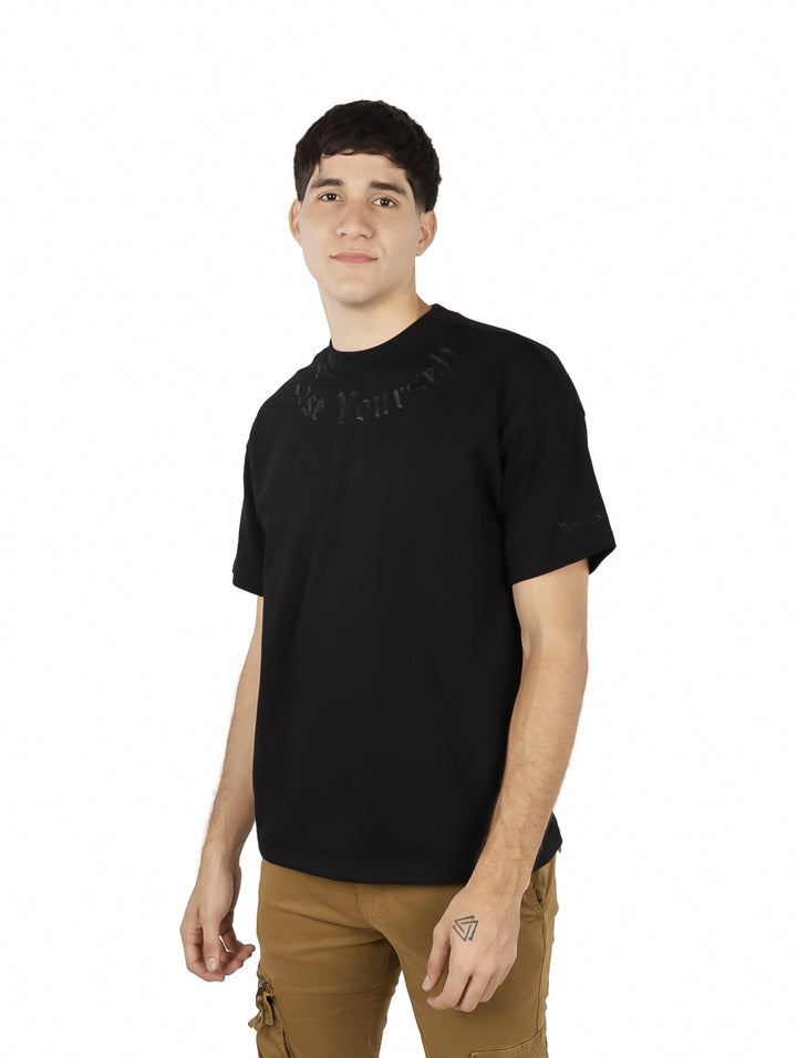 Hombre vistiendo una playera negra de manga corta marca FIMONS y pantalones cargo color café.