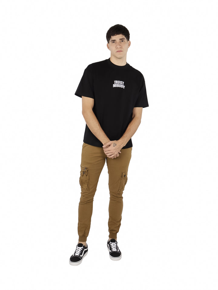 Hombre vistiendo playera oversize color negro con texto blanco &