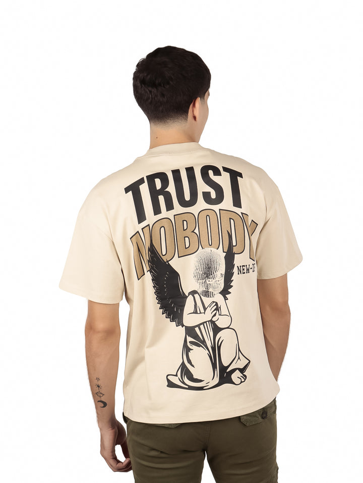 Hombre vistiendo una playera beige de manga corta con texto en el pecho.