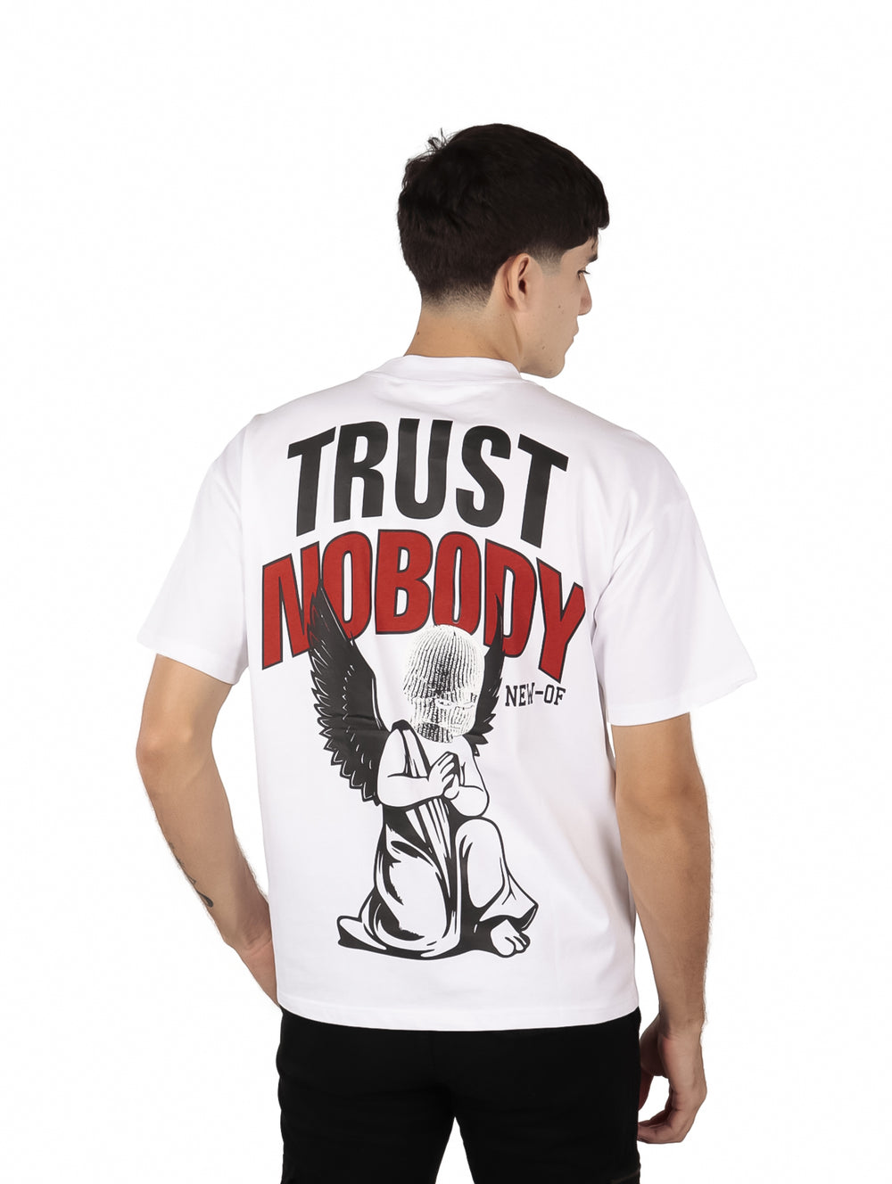 Hombre vistiendo una playera blanca oversize de manga corta con texto negro en el pecho.