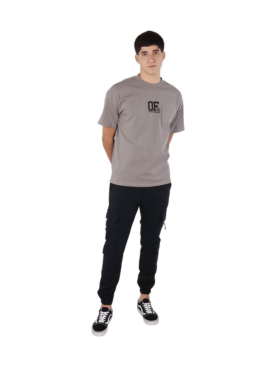 Hombre vistiendo una playera de manga corta color gris con un logotipo negro en el pecho.