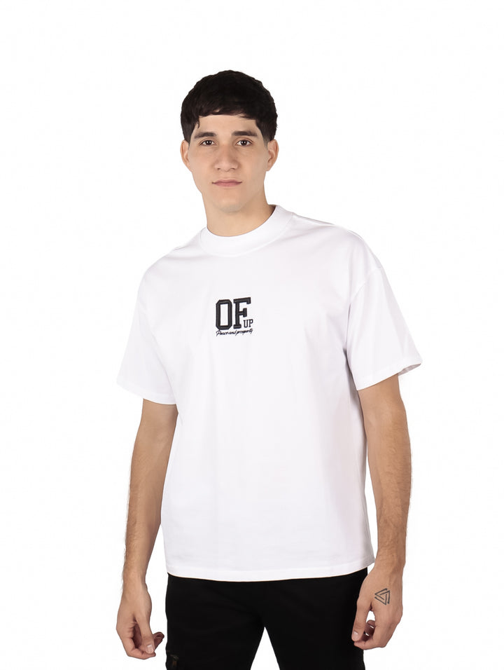 Hombre vistiendo una playera blanca oversize de manga corta con estampado negro en el pecho.