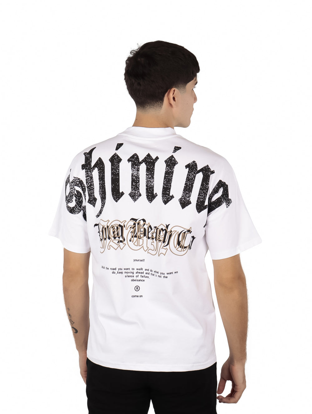 Hombre vistiendo playera blanca de manga corta con estampado negro en el pecho.