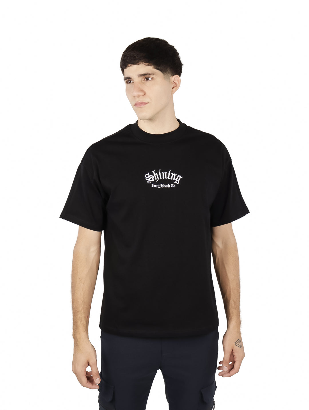 Hombre vistiendo playera negra de manga corta con estampado blanco en el pecho.