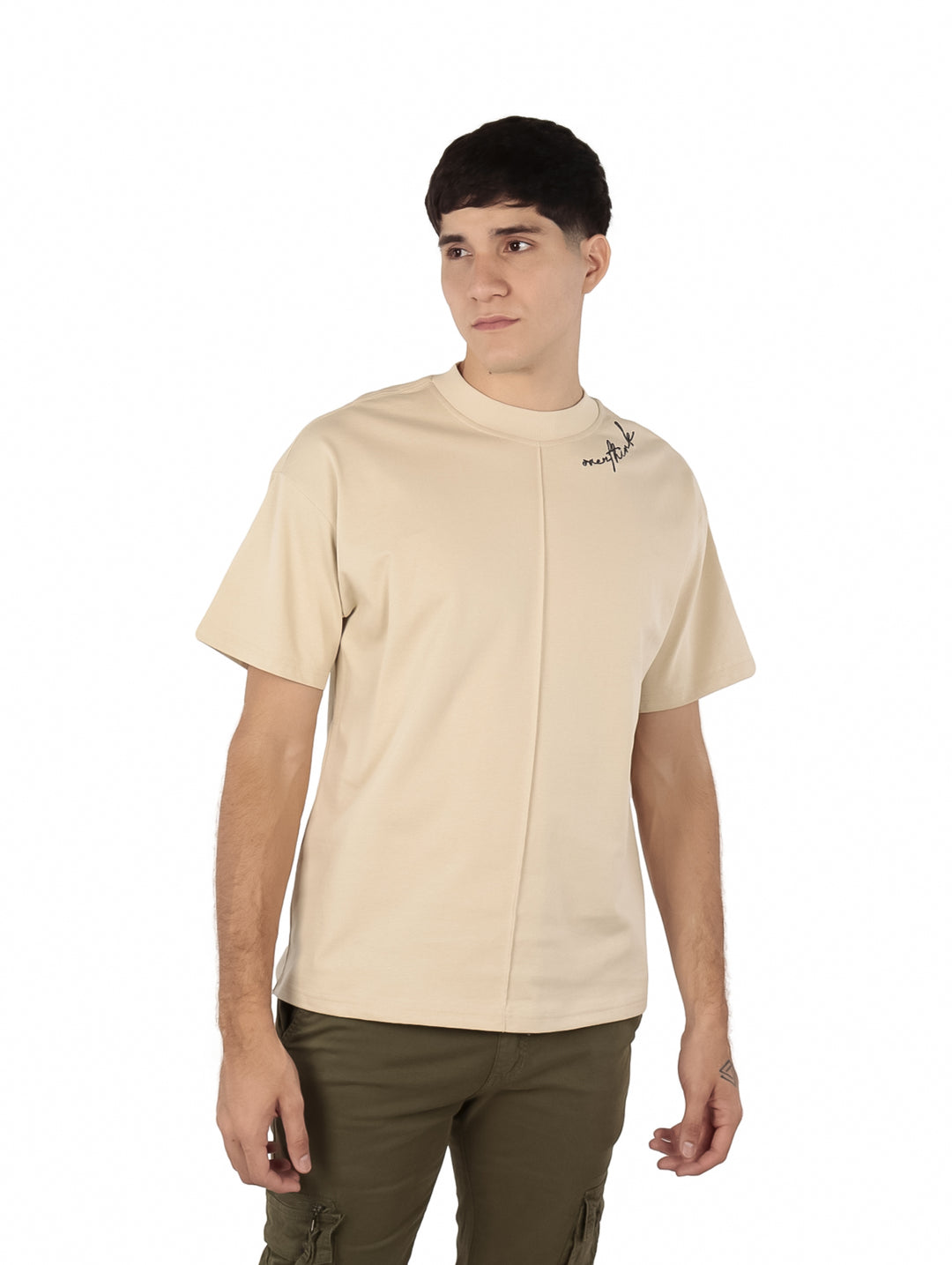 Hombre vistiendo playera oversize color beige de manga corta y cuello redondo.