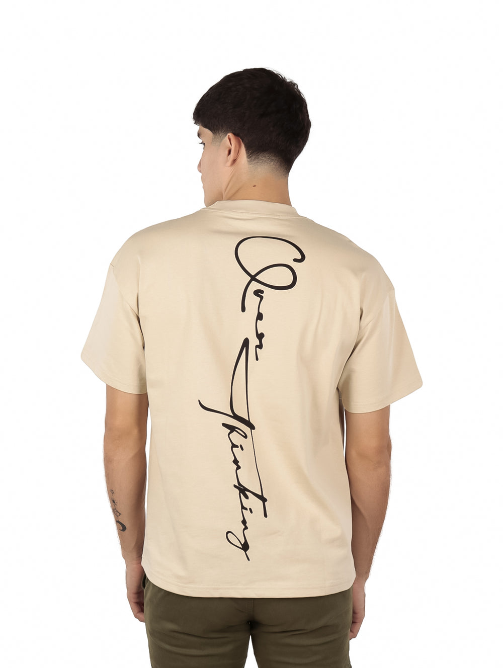 Hombre vistiendo playera oversize color beige de manga corta y cuello redondo.