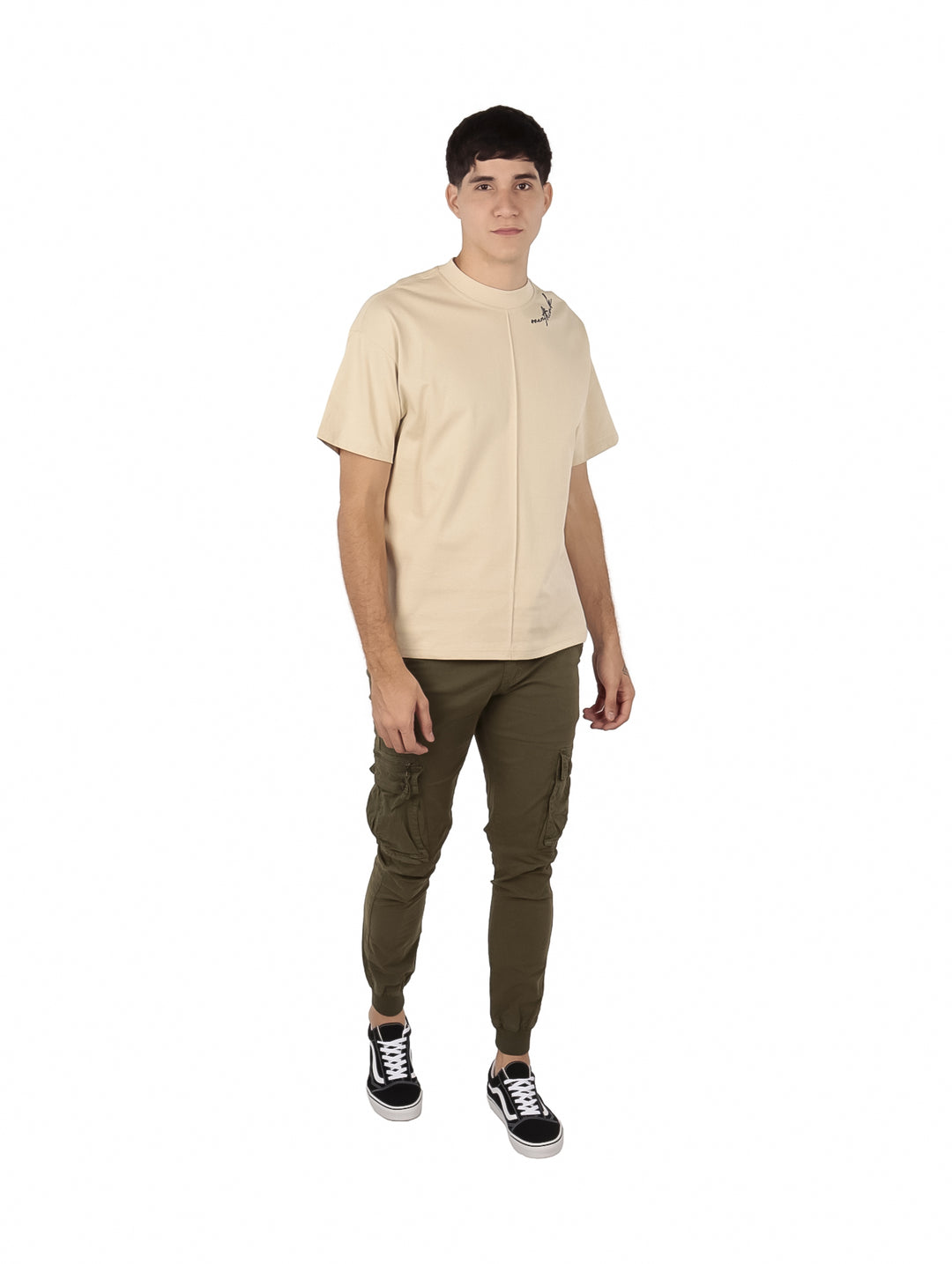 Hombre vistiendo playera oversize color beige de manga corta y cuello redondo.