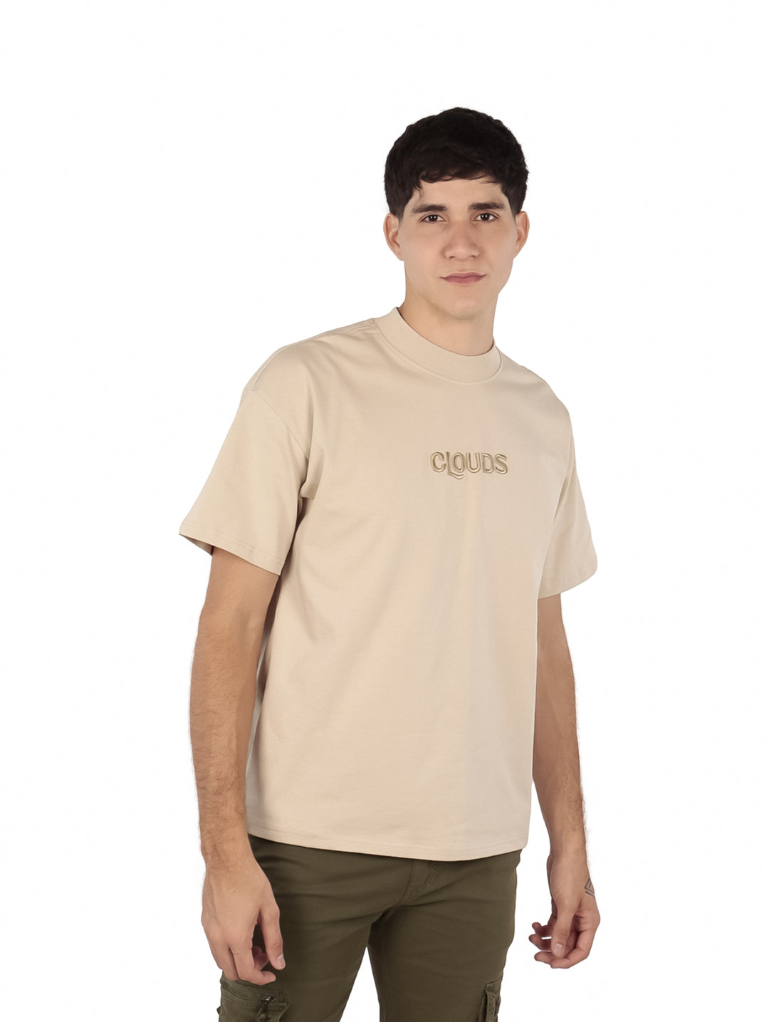Hombre vistiendo playera oversize color beige con texto 'CLOUDS' en el pecho.