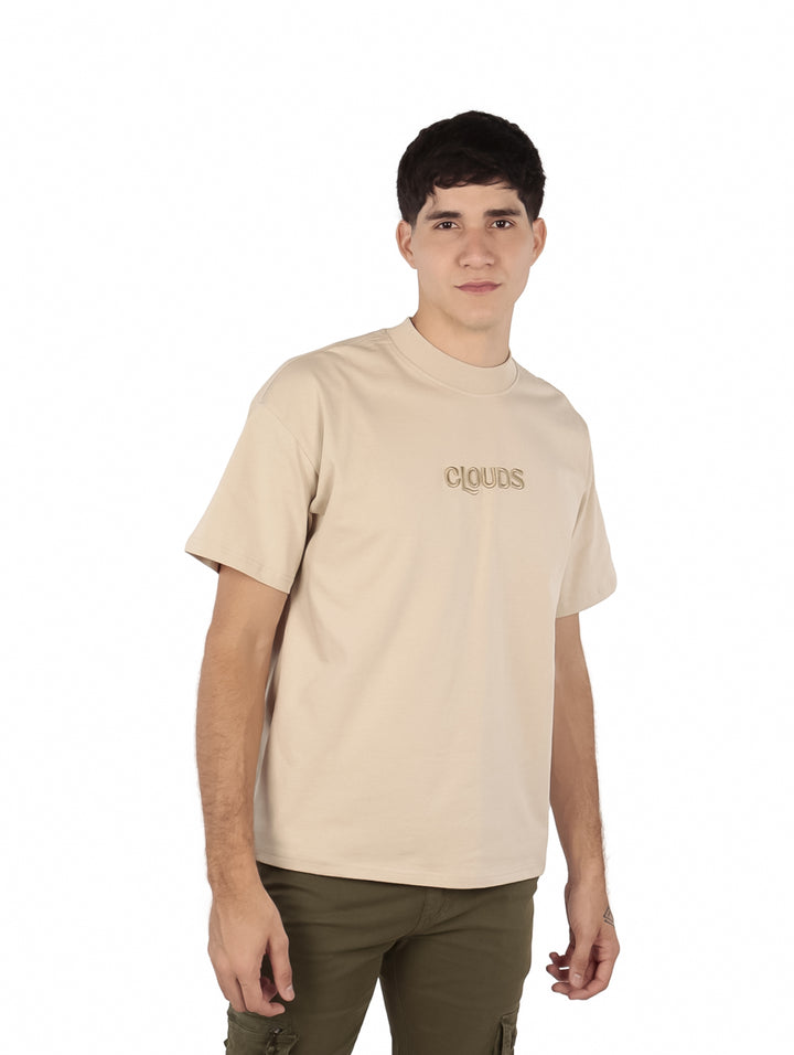Hombre vistiendo playera oversize color beige con texto &