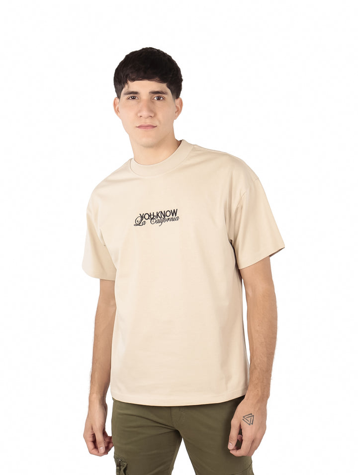 Hombre vistiendo playera oversize color khaki de la marca FIMONS con logotipo en el pecho.