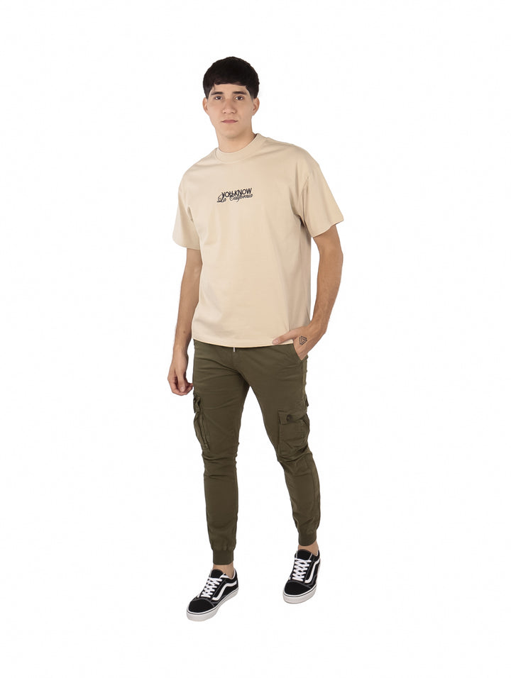 Hombre vistiendo playera oversize color khaki de la marca FIMONS con logotipo en el pecho.