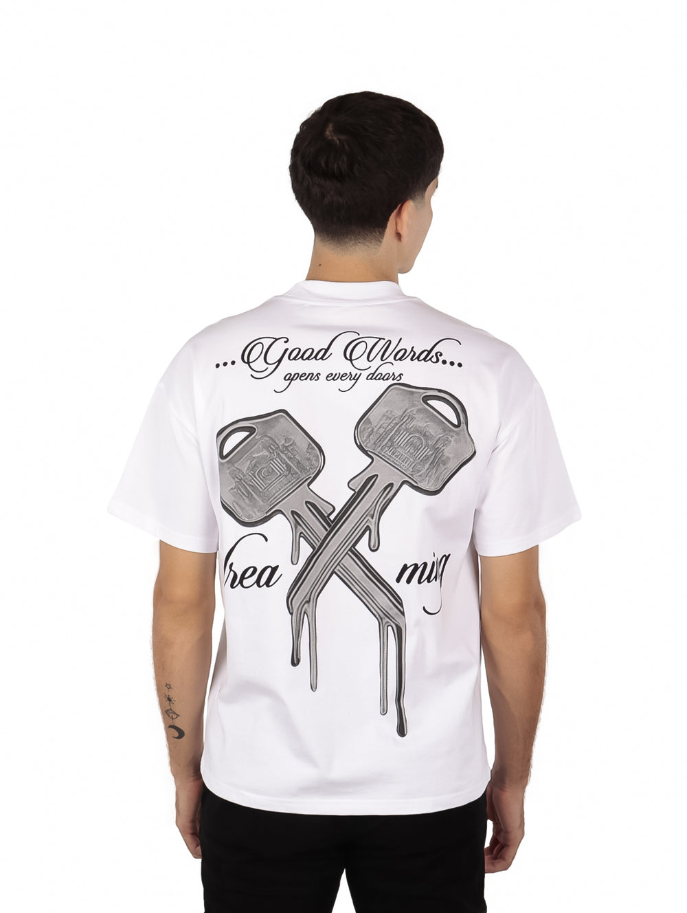 Hombre vistiendo playera oversize color blanco con un pequeño estampado de texto en el pecho.