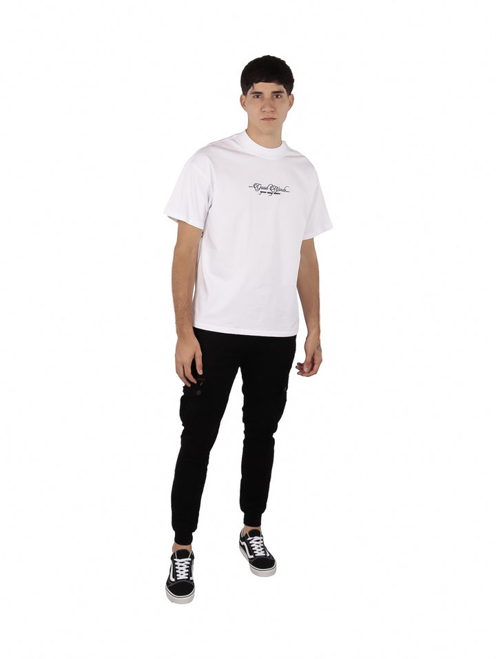 Hombre vistiendo playera oversize color blanco con un pequeño estampado de texto en el pecho.