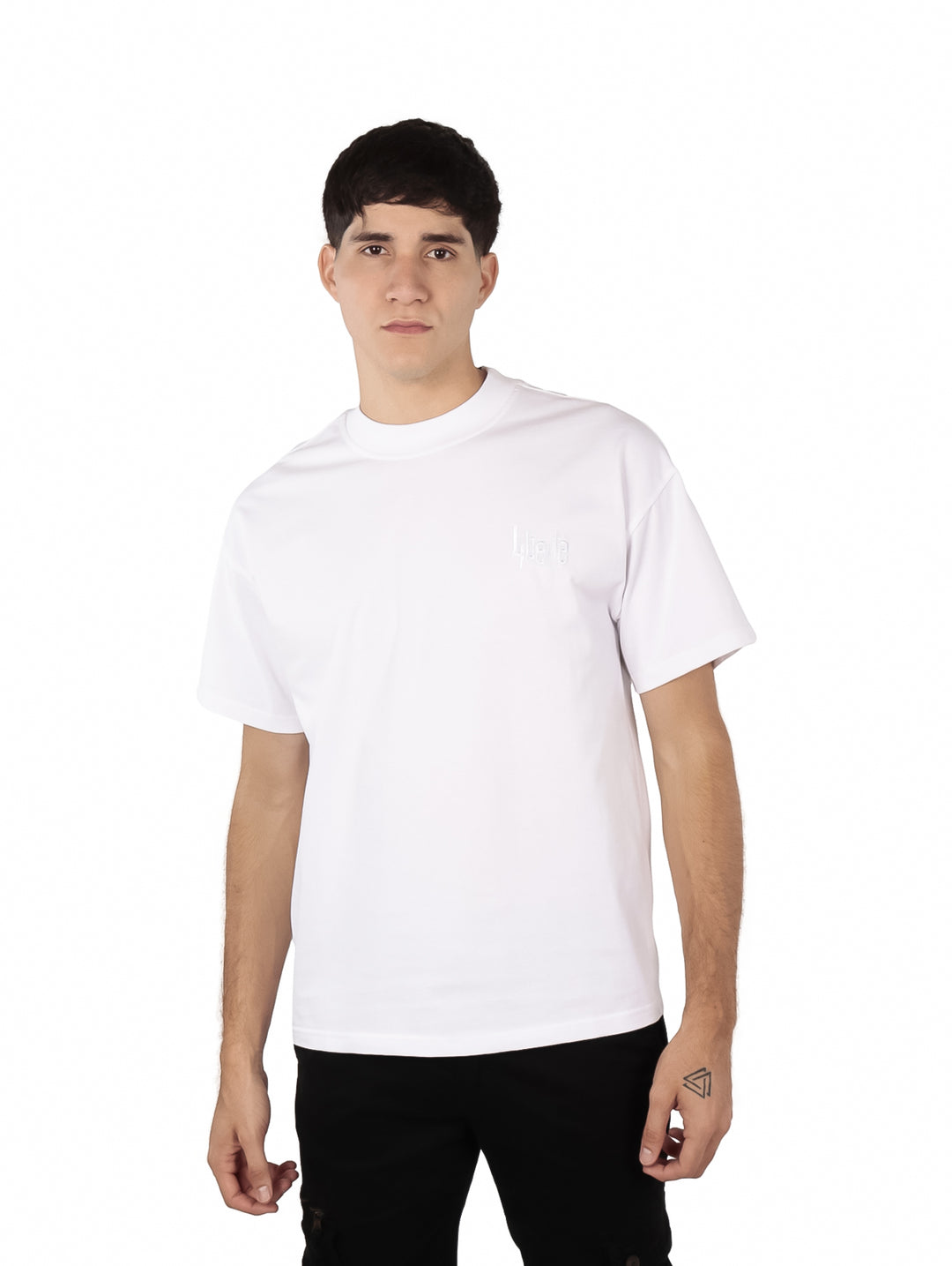 Hombre vistiendo una playera blanca oversize de manga corta y cuello redondo.