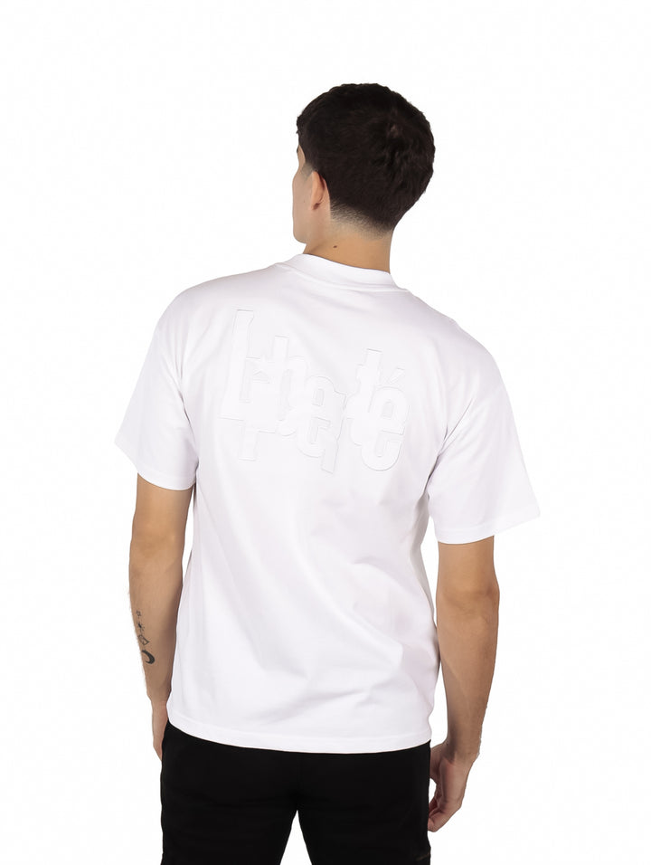 Hombre vistiendo una playera blanca oversize de manga corta y cuello redondo.